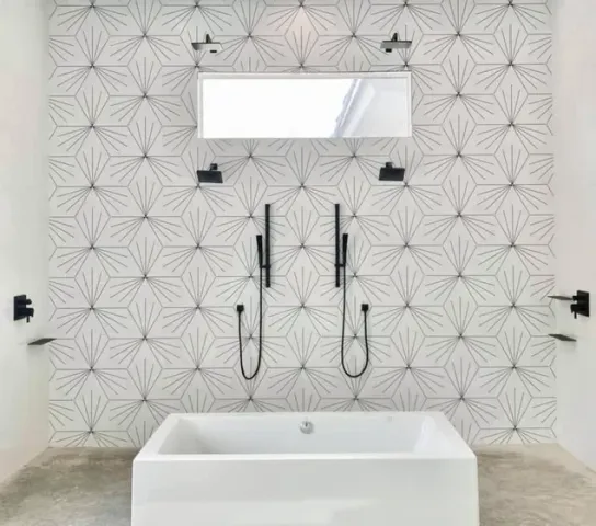 Bathroom remodel featuring a freestanding soaking tub, dual black handheld showers and star-pattern tile