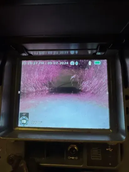 Drain camera inspection monitor showing tree roots growing inside a sewer pipe