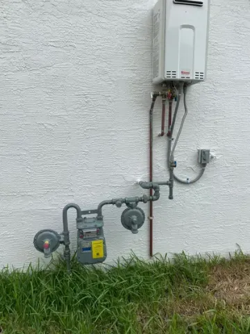 A gas meter is attached to a wall next to a water heater.